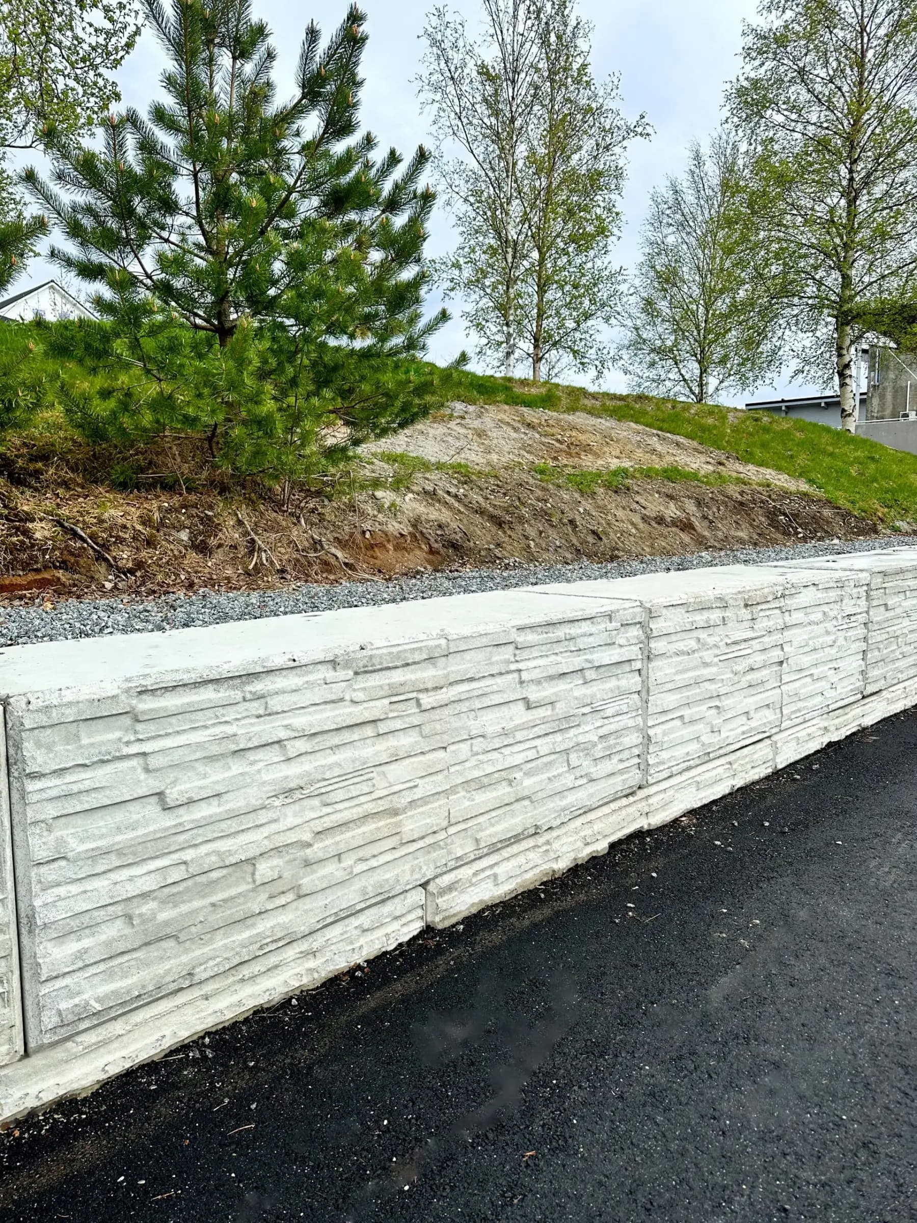 Støttemur av betongblokker langs en vei
